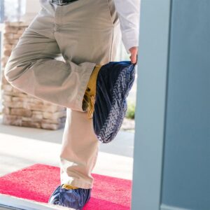 ShuBee shoe covers in dark blue being put on at the door of a client's home