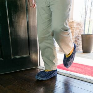 ShuBee shoe covers in dark blue walking into a home
