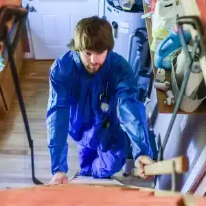 man climbing attic in Trishield coverall