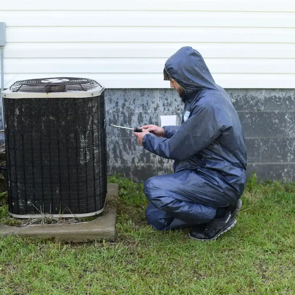 man squatting in waterproof coverall